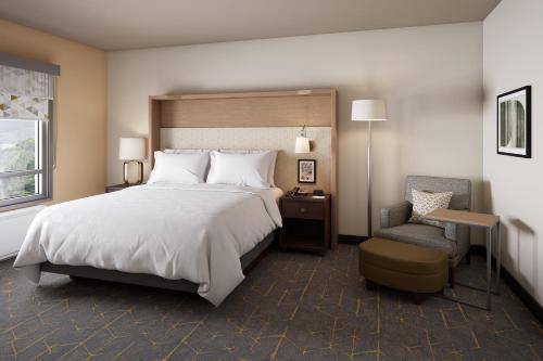 廷利公园Holiday Inn - Chicago - Tinley Park, an IHG Hotel的一间卧室配有一张大床和一把椅子