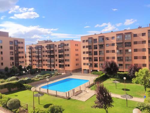 马德里Deyanira New Suite Madrid Airport的公寓大楼,公园内设有游泳池