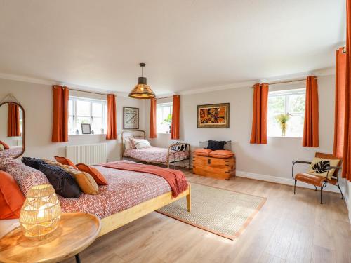 艾尔斯伯里Yew Tree Farm的一间卧室配有带橙色窗帘的大床