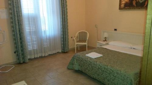 布林迪西曼佐尼住宿加早餐旅馆的卧室配有床、椅子和窗户。