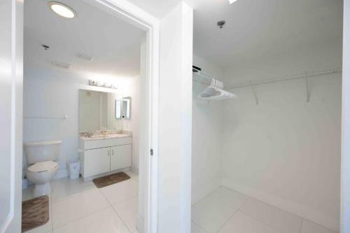 迈阿密Luxurious 1 Bed Apartment in Brickell • Ocean View的白色的浴室设有卫生间和水槽。