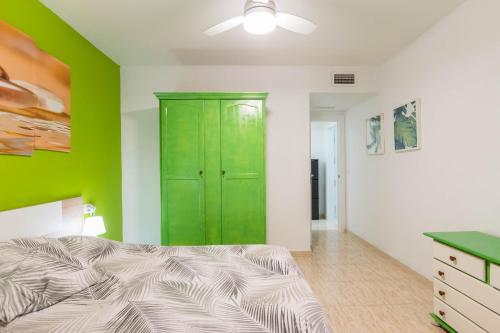 穆尔西亚Apartamento Marqués de Ordoño的一间卧室配有绿色橱柜和一张床