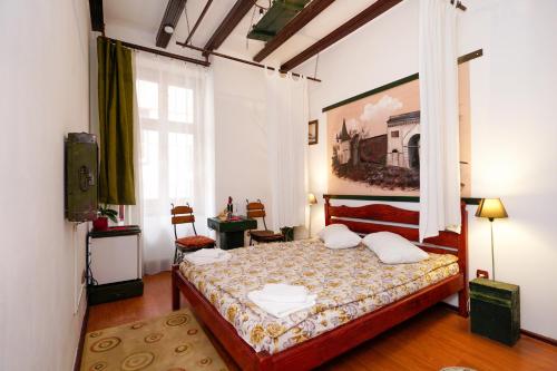 布拉索夫Pensiunea Noemi的卧室配有一张床,墙上挂有绘画作品