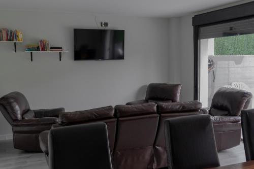 苏维里Suseia的客厅配有棕色真皮沙发和椅子