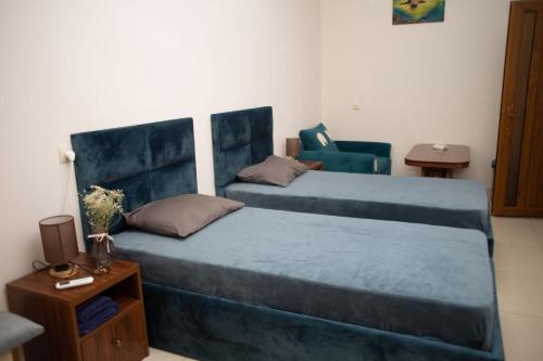 埃里温Apex rest house的一间卧室配有两张床和椅子