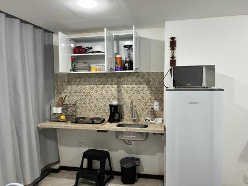 莫罗圣保罗Flat Rosebahia的小厨房配有冰箱和微波炉。