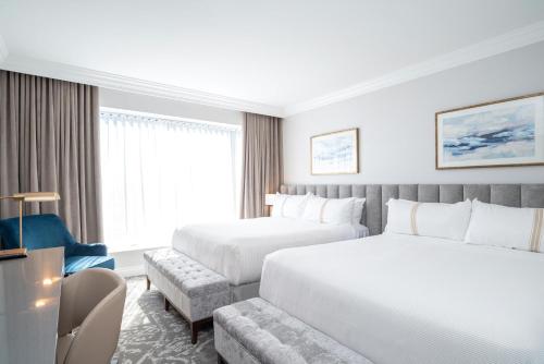 温哥华苏顿普莱斯酒店的酒店客房,设有两张床和一张沙发
