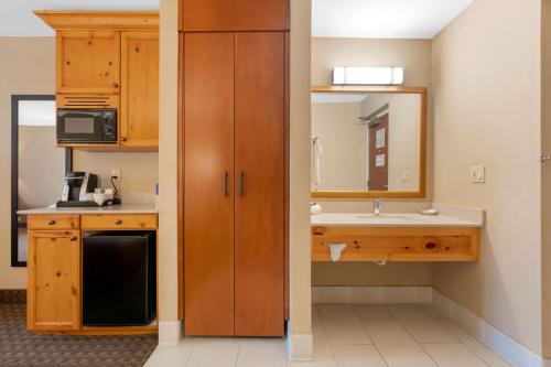 克拉马斯福尔斯Best Western Plus Olympic Inn的一个带水槽和镜子的小厨房