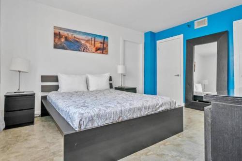 迈阿密海滩Amazing apartment in South Beach, Ocean drive的一间卧室配有一张床和蓝色的墙