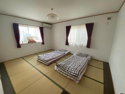 大津琵琶湖畔澄の宿的带2扇窗户的客房内的2张床