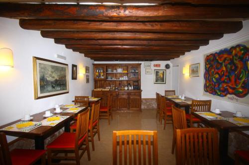 威尼斯达拉莫拉酒店的用餐室配有木桌和椅子