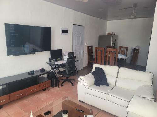 苏莎亚Sosua Apartment 4-Bedrooms的客厅配有白色沙发和平面电视。