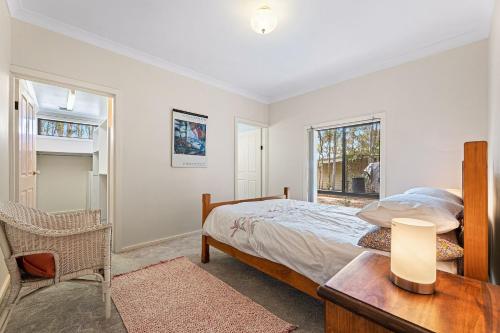 DalmenyWave Haven的一间卧室配有一张床、一张桌子和一个窗户。