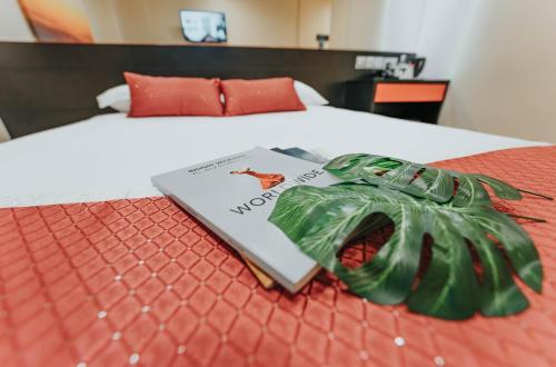 新加坡Hotel 81 Heritage的一本书坐在床上,带绿丝带