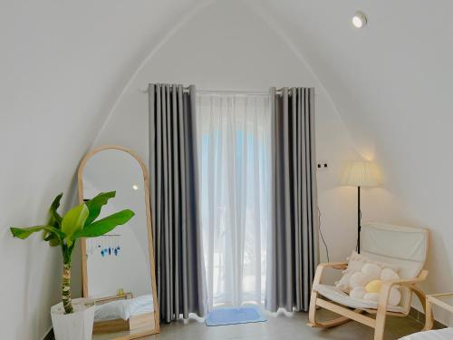 Trà VinhMalis Homestay的客房设有镜子、椅子和窗户。