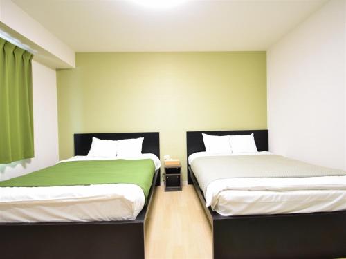 冈山Regariain - Vacation STAY 84627的两张睡床彼此相邻,位于一个房间里