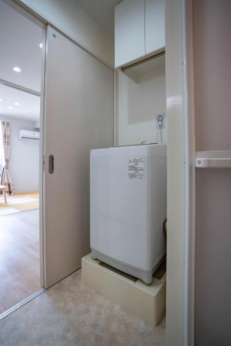 大阪震雲マンション105的一间厨房,内配白色冰箱