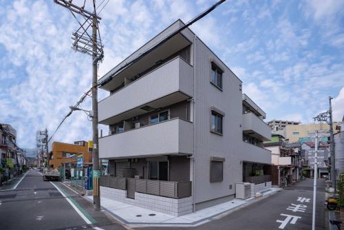 大阪震雲マンション105的街道边的白色建筑
