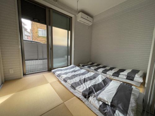 大阪震雲マンション105的一间设有两张床铺和窗户的房间