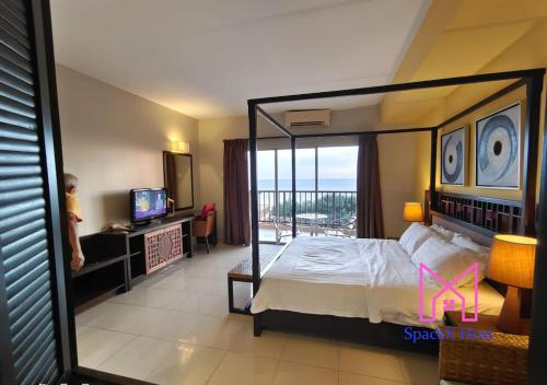 万津Gold Coast Morib Resort的一间卧室设有一张天蓬床和一个阳台