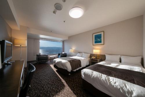 诹访市本尼亚酒店的酒店客房设有两张床和一台平面电视。