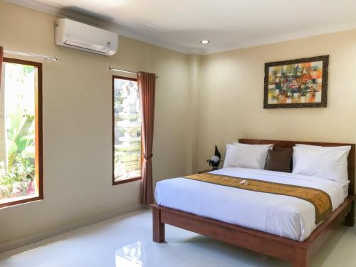 乌布Villa Dira Ubud的一间卧室设有一张床和两个窗户。
