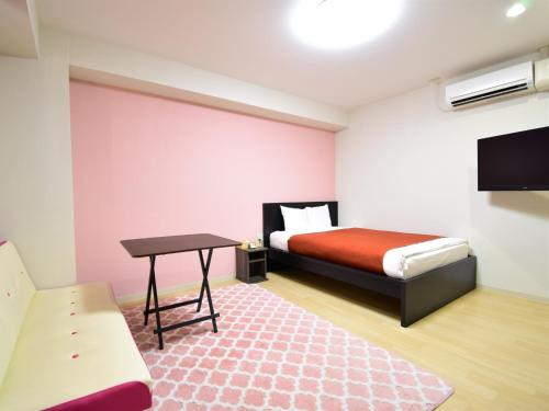 冈山Regariain - Vacation STAY 84905的一间卧室配有一张床、一张桌子和一台电视。