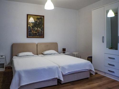 卡尔洛瓦茨Apartment Dubovac的卧室配有一张床,墙上挂有绘画作品