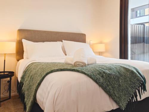 奥克兰Luxurious 2 bedroom apartment Free secure parking的一间卧室配有一张带绿毯的大床