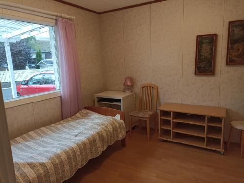 拉彭兰塔Saimaa home的一间卧室配有一张床、一张书桌和一个窗户。