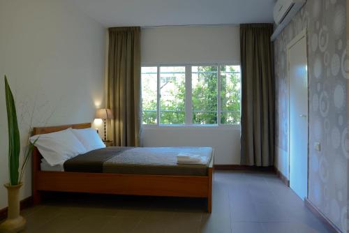 帕拉马里博Mathurin Appartementen的一间卧室设有一张床和一个大窗户