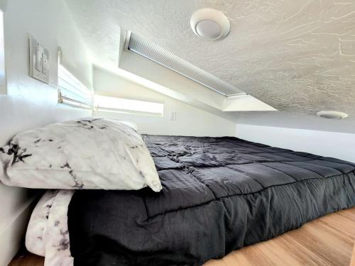 Apple ValleyDesigner Modern Tiny Home w All of The Amenities的一间位于客房内的带黑色床的卧室