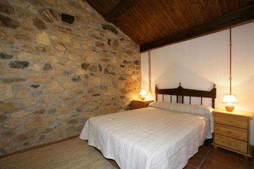 Soto De AguesCasa Rural El Puente de Agues的一间卧室设有一张床和石墙