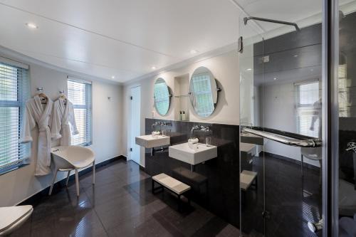 克尼斯纳Villa Afrikana Guest Suites by Knysna Paradise Collection的一间带两个水槽和玻璃淋浴间的浴室