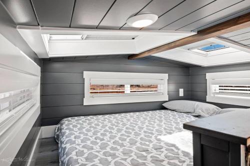 Apple ValleyUnder The Sea Tiny Home的一间小卧室,配有床和2个窗户