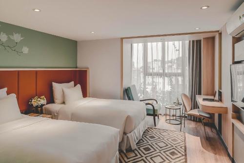 河内Hanoi Le Jardin Hotel & Spa的酒店客房设有两张床和窗户。
