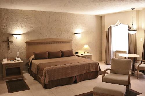 科尔多瓦Suites Layfer, Córdoba, Veracruz, México的一间卧室配有一张大床和一把椅子