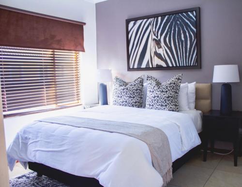 SandtonBeautiful 2 bedroom Apartment near Monte Casino的卧室设有一张白色大床和一扇窗户。