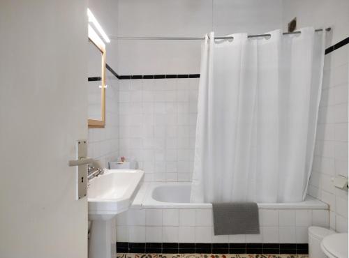 拉拉古纳Casa Julia的带浴缸、水槽和淋浴帘的浴室