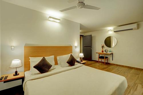 卡兰古特Hotel Plaza Inn by Rio的卧室配有一张白色的大床和一张桌子