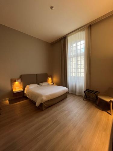 蓬塔穆松阿巴耶酒店的一间卧室配有一张带两盏灯的床和一扇窗户。