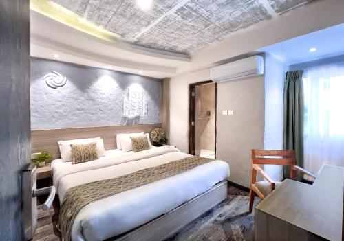 加德满都Vastu Boutique Hotel的酒店客房设有一张大床和一张书桌。