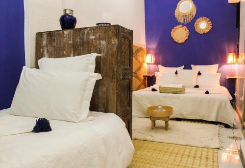 马拉喀什里亚德阿姆拉酒店的一间卧室配有两张带白色枕头的床