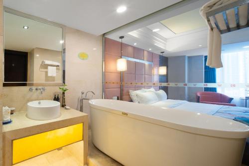 佛山百盛达丽呈睿轩酒店（佛山千灯湖公园店）的带浴缸、水槽和床的浴室