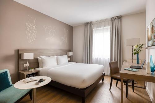 布鲁塞尔馨乐庭布鲁塞尔公寓酒店的酒店客房设有一张大床和一张书桌。