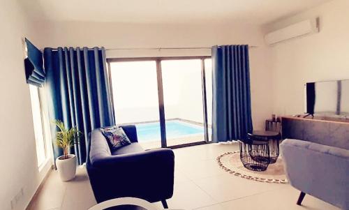 弗利康弗拉克3bed villa with private pool and rooftop with a sea view in flic-en-flac, Mauritius的带沙发和大窗户的客厅