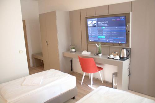 慕尼黑Isar City Hotel的客房设有一张床和一张带显示器的书桌