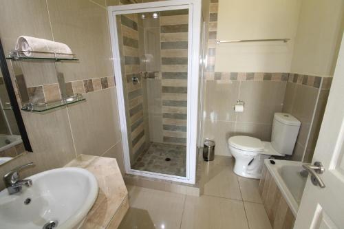 乌旺戈海滩Saints View Resort Unit 1的带淋浴、盥洗盆和卫生间的浴室