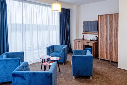 布勒伊拉RaAy的一间设有蓝色椅子、电视和桌子的房间