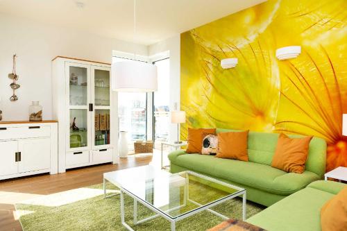 瓦伦Traumfängerloge -Hafenresidenz的客厅设有绿色沙发和黄色墙壁
